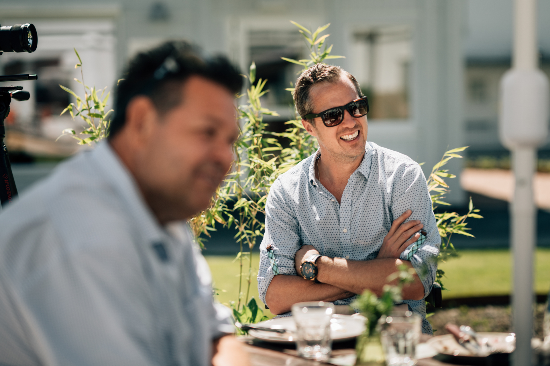Slemmestad centrum i Norge, två glada män sitter ute i solen och dricker kaffe