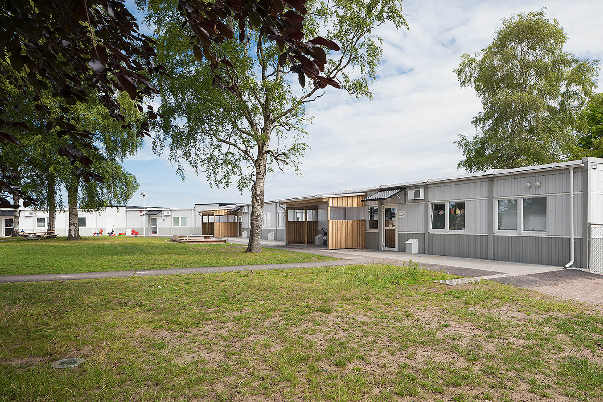 Nordala förskola i Vallås, expandias moduler, grå och vit fasad, träd och gröntområde