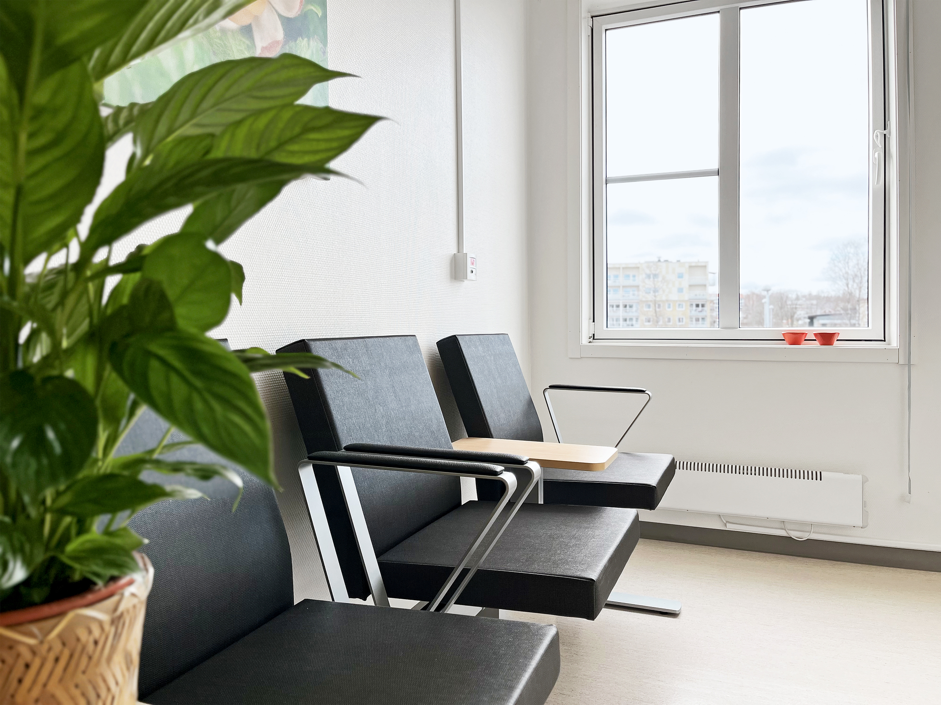 Väntrum med stolar och bord vid fönster på Skillingaryds vårdcentral, inredd i ljusa och funktionella vårdmoduler från Expandia