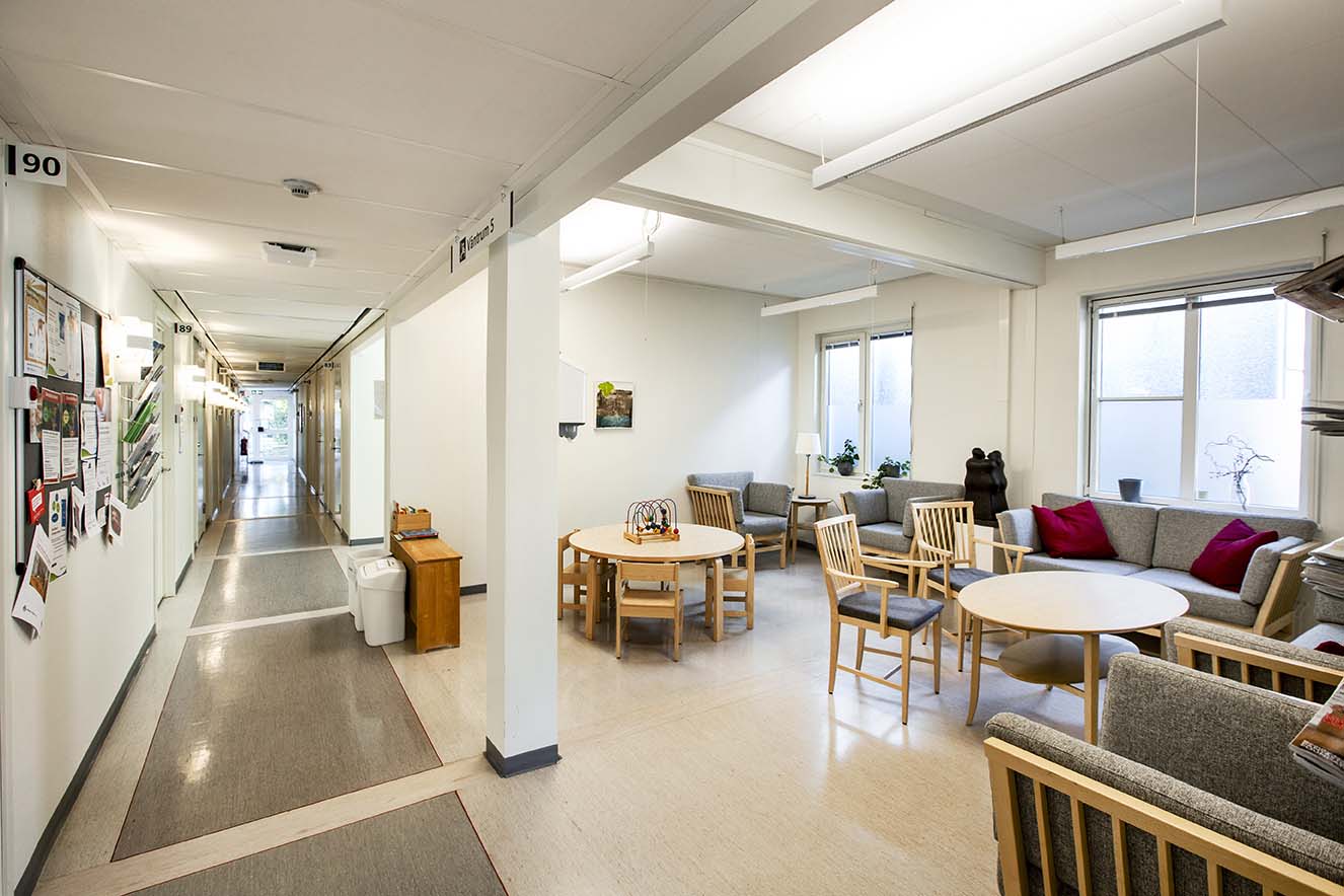 Väntrum och korridor i tillfällig vårdcentral uppförd med moduler från Expandia, med sittgrupper, runda bord och informationsvägg.
